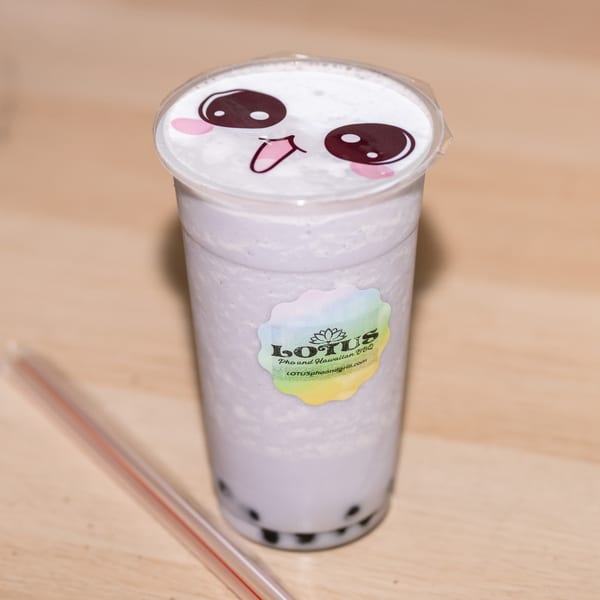 A taro bubble tea from Lotus Pho and Hawaiian BBQ, with a cute face on the lid.