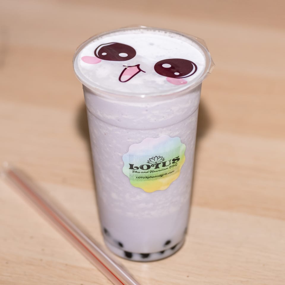 A taro bubble tea from Lotus Pho and Hawaiian BBQ, with a cute face on the lid.